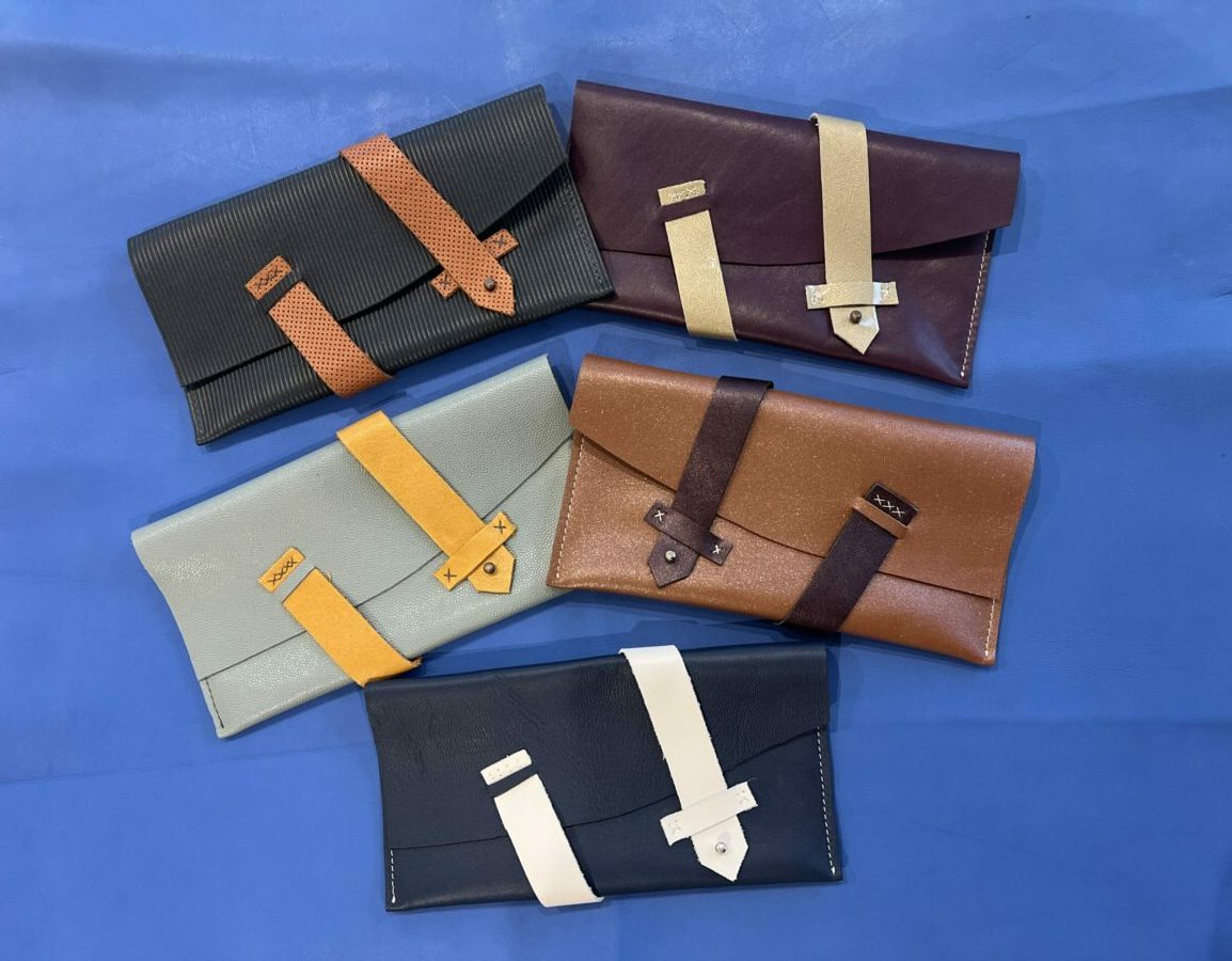 pochette avec fermeture par une lanière cuir